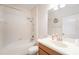 Bright bathroom featuring a shower-over-tub, a white vanity, and a decorative mirror at 13820 Chalk Hill Pl, Riverview, FL 33579