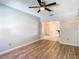 Bright living room with wood-look floors, ceiling fan, and neutral wall color at 15536 George Blvd, Clearwater, FL 33760