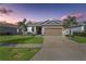 Beautiful single-Gathering home featuring a two-car garage, well-manicured lawn and decorative stone accents at 16625 Goose Ribbon Pl, Wimauma, FL 33598