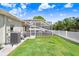 Well-maintained backyard with lush green lawn, a screened-in pool, and a white picket fence at 16843 Harrierridge Pl, Lithia, FL 33547