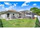 Spacious backyard featuring a green lawn, a screened-in pool, and a white fence at 16843 Harrierridge Pl, Lithia, FL 33547