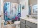 Bathroom features a shower with dolphin shower curtain, a gray vanity, and granite countertops at 16843 Harrierridge Pl, Lithia, FL 33547