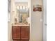 Bathroom featuring a granite countertop, framed mirror, vanity lighting, and a tiled shower at 16843 Harrierridge Pl, Lithia, FL 33547