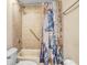 Bathroom featuring shower with handrails, nautical themed shower curtain and tile surround at 16843 Harrierridge Pl, Lithia, FL 33547
