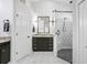 Modern bathroom with a black vanity, granite countertop, and a seamless glass shower at 16843 Harrierridge Pl, Lithia, FL 33547
