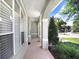 Charming front porch with tiled flooring, supporting columns, and views of landscaped greenery at 16843 Harrierridge Pl, Lithia, FL 33547