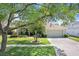 Landscaped front yard with healthy grass, and decorative trees highlighting this cozy one-story home at 16843 Harrierridge Pl, Lithia, FL 33547