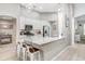 Bright kitchen featuring white cabinets, a marble countertop island with barstool seating, and modern stainless steel appliances at 16843 Harrierridge Pl, Lithia, FL 33547