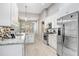 Stylish kitchen with white cabinetry, stainless steel appliances, and a mosaic backsplash that add a modern touch at 16843 Harrierridge Pl, Lithia, FL 33547