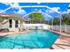 Screened in pool featuring brick pavers, a pool fence, and a beautifully landscaped backyard at 16843 Harrierridge Pl, Lithia, FL 33547