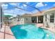 Inviting screened-in pool area featuring clear blue water, brick deck, and outdoor seating for relaxation at 16843 Harrierridge Pl, Lithia, FL 33547