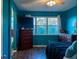 This beautiful bedroom features blue walls, hardwood floors, a ceiling fan, and lots of natural light at 19279 Stone Hedge Dr, Tampa, FL 33647