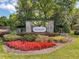 Stonegate entrance with lush landscaping, stone pillars, and a decorative gate at 20352 Falling Rock Dr, Land O Lakes, FL 34638