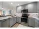 Modern kitchen with gray cabinets, stainless steel appliances, and stylish pendant lighting at 320 Island Way # 102, Clearwater Beach, FL 33767