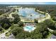 Expansive aerial view showcasing the community pool nestled amidst lush greenery, serene lake, and neighborhood homes at 3217 Partridge Point Trl, Valrico, FL 33596