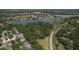 Breathtaking aerial view showcasing a lake, winding road, and neighborhood homes surrounded by mature trees and greenery at 3217 Partridge Point Trl, Valrico, FL 33596