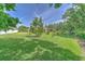 Home exterior, showing a very large, well manicured backyard with healthy green grass and trees at 3217 Partridge Point Trl, Valrico, FL 33596