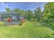Manicured backyard with healthy green grass, tropical foliage, and the enclosed pool area at 3217 Partridge Point Trl, Valrico, FL 33596