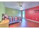 Stylish bedroom with hardwood floors, ceiling fan, large window and unique color combination for a modern look at 3217 Partridge Point Trl, Valrico, FL 33596