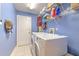 Practical laundry room with a washer, dryer, and plenty of shelving for storage solutions at 3217 Partridge Point Trl, Valrico, FL 33596