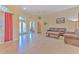 Spacious living room featuring tile floors, a leather sofa set, and a large window with red curtains at 3217 Partridge Point Trl, Valrico, FL 33596
