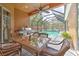 Screened-in patio with outdoor kitchen and seating area overlooking pool and landscaping at 3217 Partridge Point Trl, Valrico, FL 33596