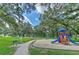 Well-maintained community playground with slides and swings surrounded by lush greenery and walking paths at 3217 Partridge Point Trl, Valrico, FL 33596
