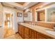 Bathroom with a double sink vanity and mirrors with views of a bathtub and shower at 3545 Seaway Dr, New Port Richey, FL 34652
