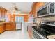 Bright kitchen featuring stainless steel appliances, tile flooring, and custom cabinetry at 3545 Seaway Dr, New Port Richey, FL 34652