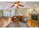 Inviting living room featuring a fireplace, ceiling fan, and comfortable brown leather sectional sofa at 3545 Seaway Dr, New Port Richey, FL 34652