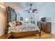 Bedroom featuring wood floors, ceiling fan, and a view of the house at 3545 Seaway Dr, New Port Richey, FL 34652