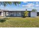 Picture of the home's backyard, featuring lush green grass and a screened lanai, perfect for outdoor relaxation at 3553 Delta Pl, Holiday, FL 34691