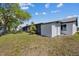Charming home exterior with well-kept lawn, mature tree, and a screened-in lanai for outdoor enjoyment at 3553 Delta Pl, Holiday, FL 34691
