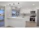 Bright kitchen features stainless appliances, white cabinets, subway tile backsplash, and modern pendant lighting at 3553 Delta Pl, Holiday, FL 34691