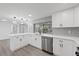 Modern kitchen with stainless dishwasher, white cabinetry, and stylish pendant lights over the island at 3553 Delta Pl, Holiday, FL 34691
