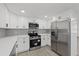 Updated kitchen featuring stainless steel appliances and white cabinetry with modern fixtures and subway tile at 3553 Delta Pl, Holiday, FL 34691