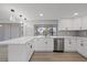 Bright kitchen with white cabinets, stainless dishwasher, and views of the water at 3553 Delta Pl, Holiday, FL 34691