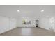 Bright and open living room featuring luxury vinyl flooring, recessed lighting, and a stylish front door at 3553 Delta Pl, Holiday, FL 34691