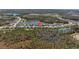 Community aerial view showcasing the neighborhood layout, surrounding trees, and pond at 3966 Tour Trce, Land O Lakes, FL 34638