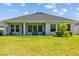 Well-maintained backyard with green grass, covered porch and cozy furniture at 3966 Tour Trce, Land O Lakes, FL 34638