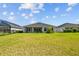Lush backyard with a well-manicured lawn and a view of the home's rear facade at 3966 Tour Trce, Land O Lakes, FL 34638