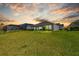 Expansive backyard at sunset, showing the lawn, landscaping, and rear of the property at 3966 Tour Trce, Land O Lakes, FL 34638