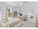 Bright bedroom with a large window, a decorative bedspread, a ceiling fan, and ample storage and desk space at 3966 Tour Trce, Land O Lakes, FL 34638