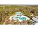 Aerial view of a sparkling community pool with palm trees, lounge chairs, and a splash pad at 3966 Tour Trce, Land O Lakes, FL 34638