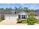 Charming single-story home featuring a 2-car garage, inviting front porch, and manicured landscaping at 3966 Tour Trce, Land O Lakes, FL 34638