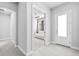 Hallway view showcasing the bright white front door and an adjacent room with a white couch and a ceiling fan at 3966 Tour Trce, Land O Lakes, FL 34638
