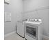 Laundry area showcasing modern washing machine and dryer with shelving for storage at 3966 Tour Trce, Land O Lakes, FL 34638