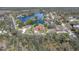 Aerial view of the community, showcasing the lake, streets, and various homes at 4404 Lake In The Woods Dr, Spring Hill, FL 34607