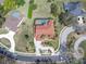 Aerial shot of the home featuring well-maintained landscaping, a circular driveway, and sparkling pool at 4404 Lake In The Woods Dr, Spring Hill, FL 34607