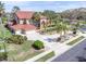 Expansive property showcasing a red-roofed home, a water fountain, a long driveway, and mature trees at 4404 Lake In The Woods Dr, Spring Hill, FL 34607